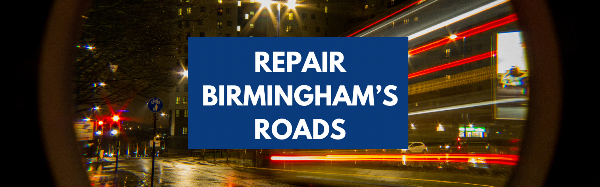 A blurred picture of an open road through a city centre. Text with a blue underlay reads, Repair Birmingham's Roads.