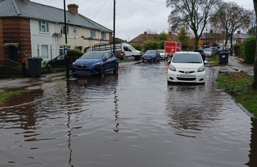 Flooded road with cars showing water to mid wheel level