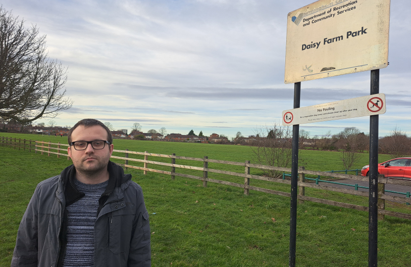 Cllr Higgs stood next to the sign for Daisy Farm Park